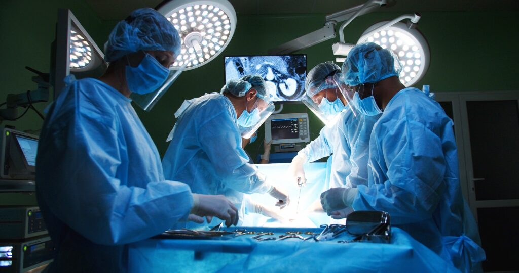Inneos | Manufacturing Technology Doctors in an operating room with a screen in the background.